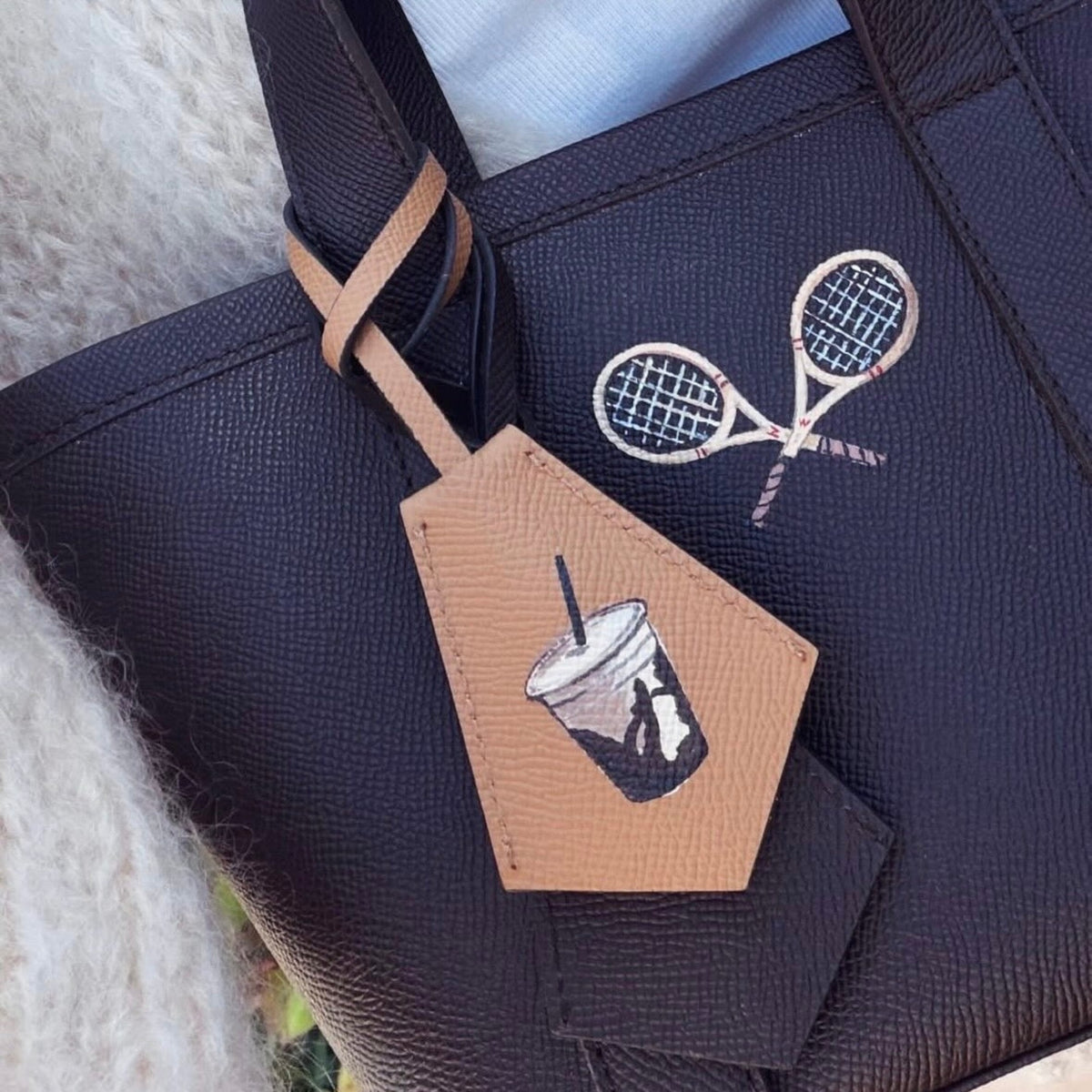 The Tennis Tote — a one-of-a-kind leather boat tote hand-painted by Gabby with two crossed racquets, 15 Parker